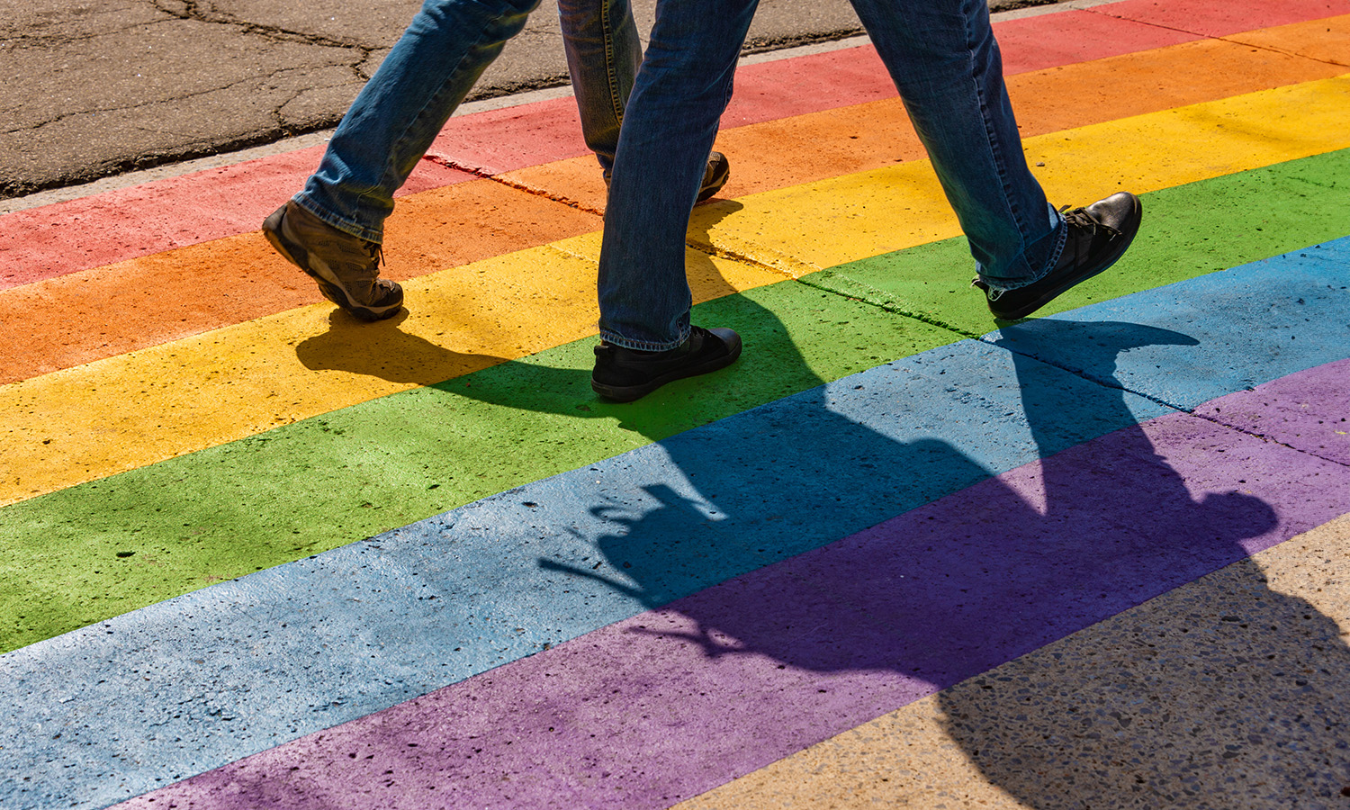 Two people walking on rainbow sidewalk. Therapy for LGBTQIA concerns