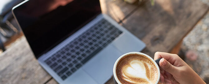 Laptop and latte for online therapy in Raleigh